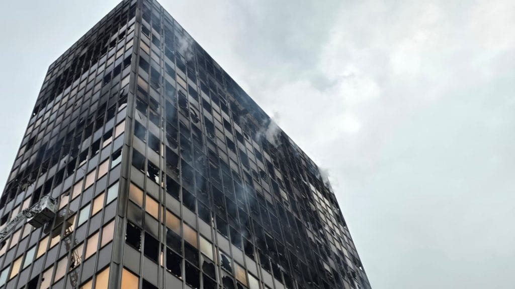 Prikazuje unutrašnjost ili vanjski dio nebodera Vjesnika nakon požara s pripadnicima HCPI-a kako postavljaju mjerne uređaje.