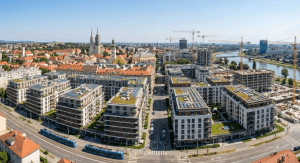 Panoramski pogled na Zagreb 2026.: moderne novogradnje i građevinski kranovi na horizontu iznad rijeke Save.